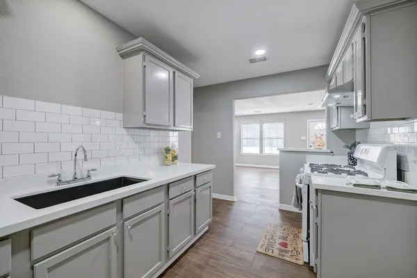 a view of a big room with wooden floor and windows
