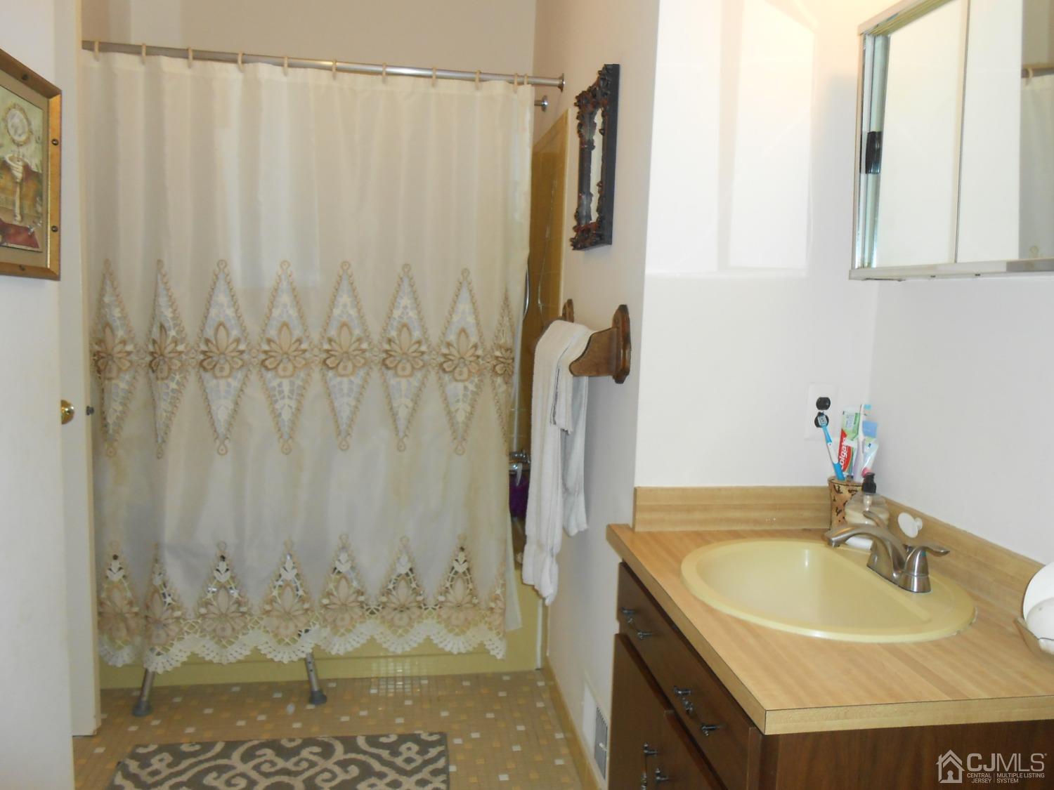 93 Pheasant Run Edison, NJ 08820 - Photo 18 of 24 a bathroom with a granite countertop sink and a mirror