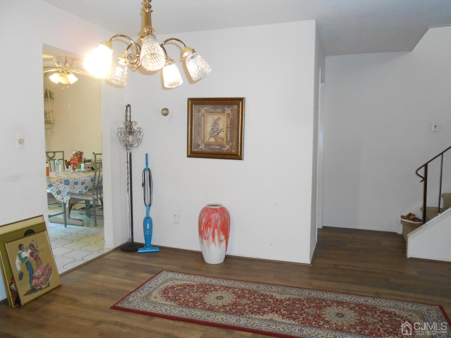 93 Pheasant Run Edison, NJ 08820 - Photo 6 of 24 a view of a livingroom with wooden floor and a chandelier