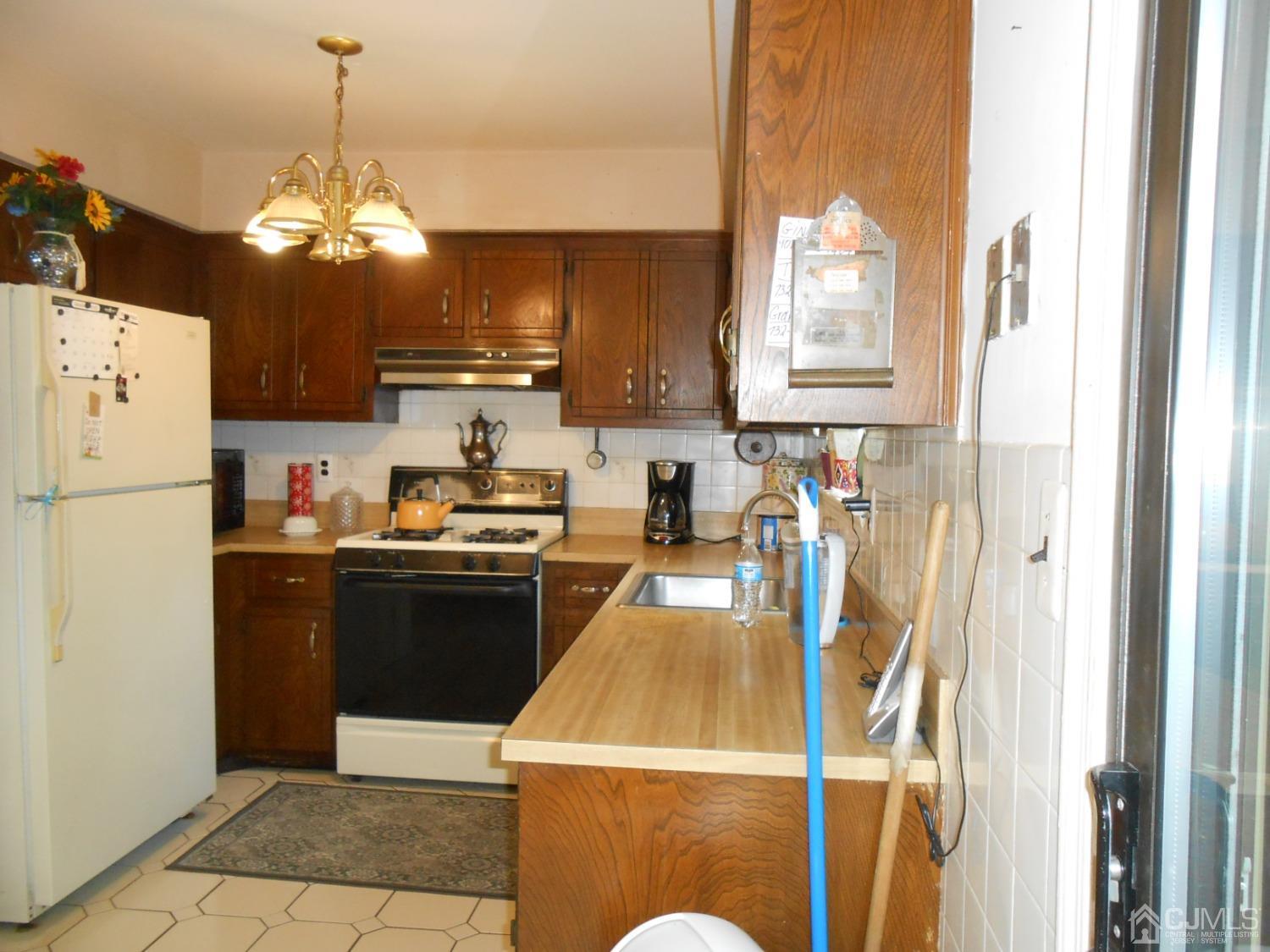 93 Pheasant Run Edison, NJ 08820 - Photo 10 of 24 a kitchen with stainless steel appliances granite countertop a refrigerator a sink dishwasher a dining table and chairs with wooden floor