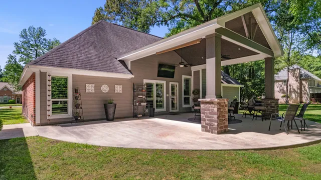 a spacious bedroom with a bed a couch and a flat tv screen on dresser
