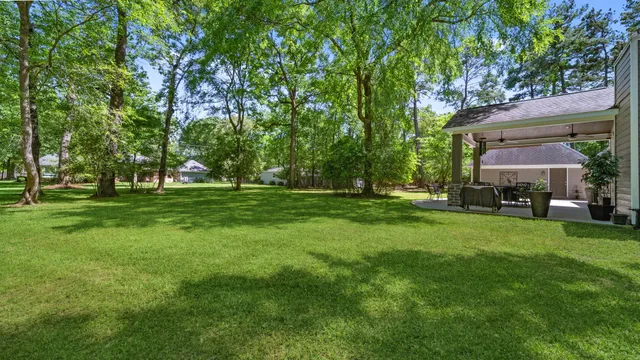 an aerial view of residential houses with outdoor space and trees all around