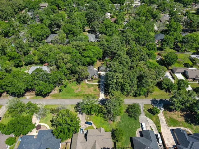 an aerial view of residential house with outdoor space and trees all around