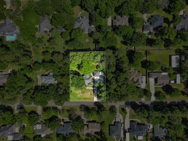 an aerial view of residential house with outdoor space and trees all around