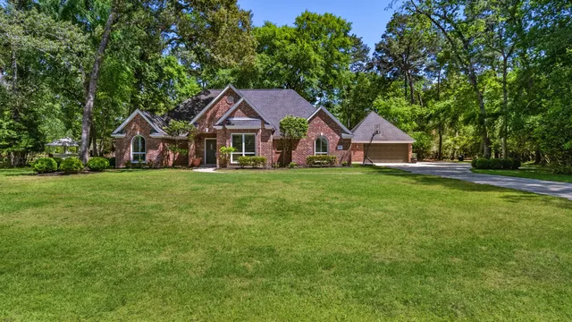 a front view of a house with a yard and trees