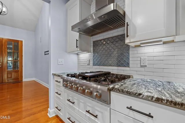 a view of an empty room with a fireplace and windows