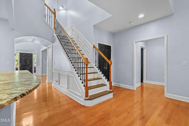 an empty room with a chandelier fan and windows