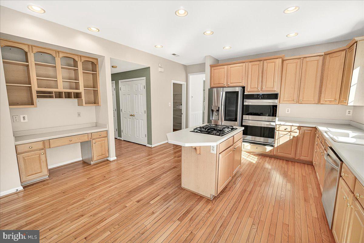 19332 Cissel Manor Drive Poolesville, MD 20837 - Photo 26 of 81 a kitchen with stainless steel appliances wooden floors and wooden cabinets