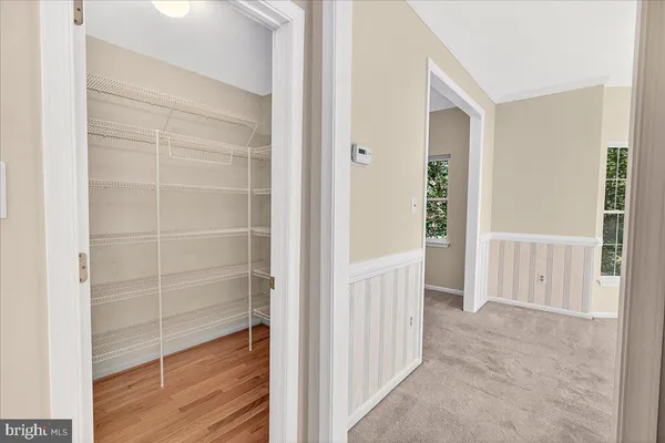 a view of walk in closet with empty racks