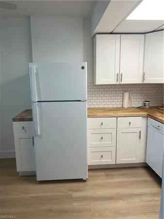a kitchen with white cabinets and white appliances