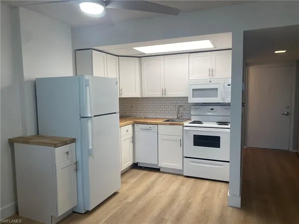 a kitchen with a refrigerator stove and white cabinets