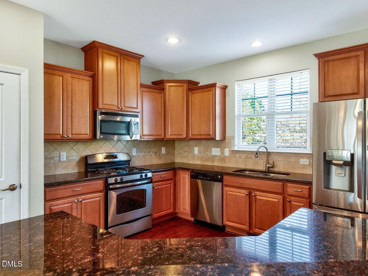 1308 Cornell Place Raleigh, NC 27607 - Photo 4 of 31 a kitchen with stainless steel appliances granite countertop wooden floor sink stove and granite counter top