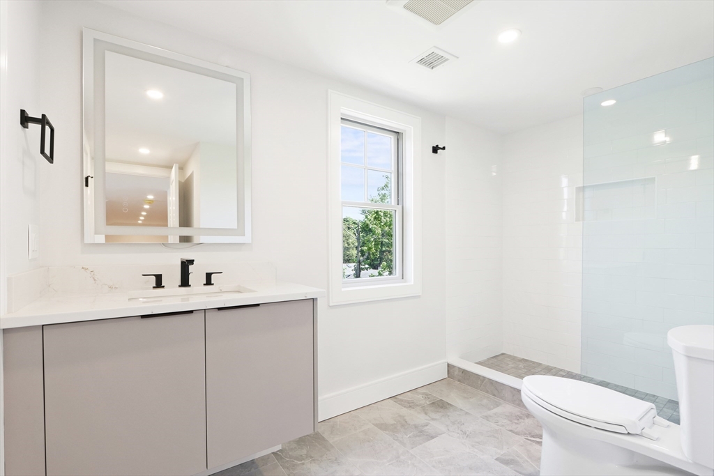 35 Mignon Road Newton, MA 02465 - Photo 36 of 42 a bathroom with a toilet a sink a mirror a window and vanity