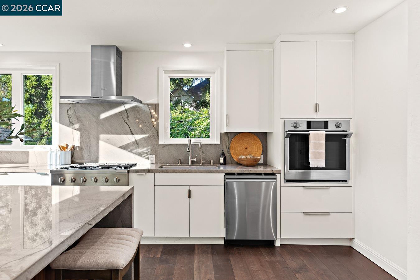 85 Ardmore Road Kensington, CA 94707 - Photo 14 of 45 a kitchen with kitchen island granite countertop a stove a sink and white cabinets with wooden floor