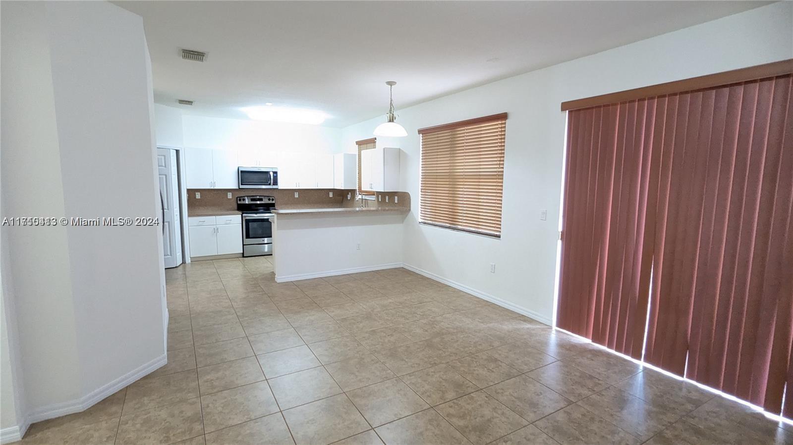 11840 Southwest 154th Avenue, Unit 11840 Miami, FL 33196 - Photo 19 of 61 a view of a kitchen with a sink cabinets and a window