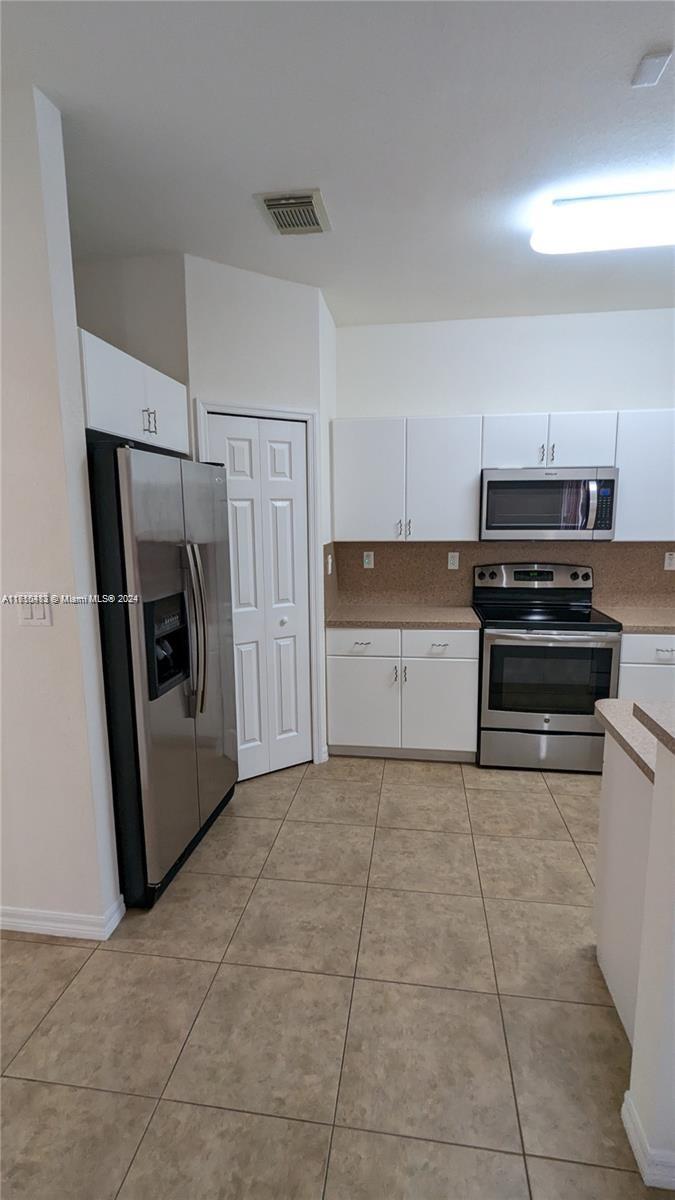 11840 Southwest 154th Avenue, Unit 11840 Miami, FL 33196 - Photo 22 of 61 a kitchen with a refrigerator and a stove top oven