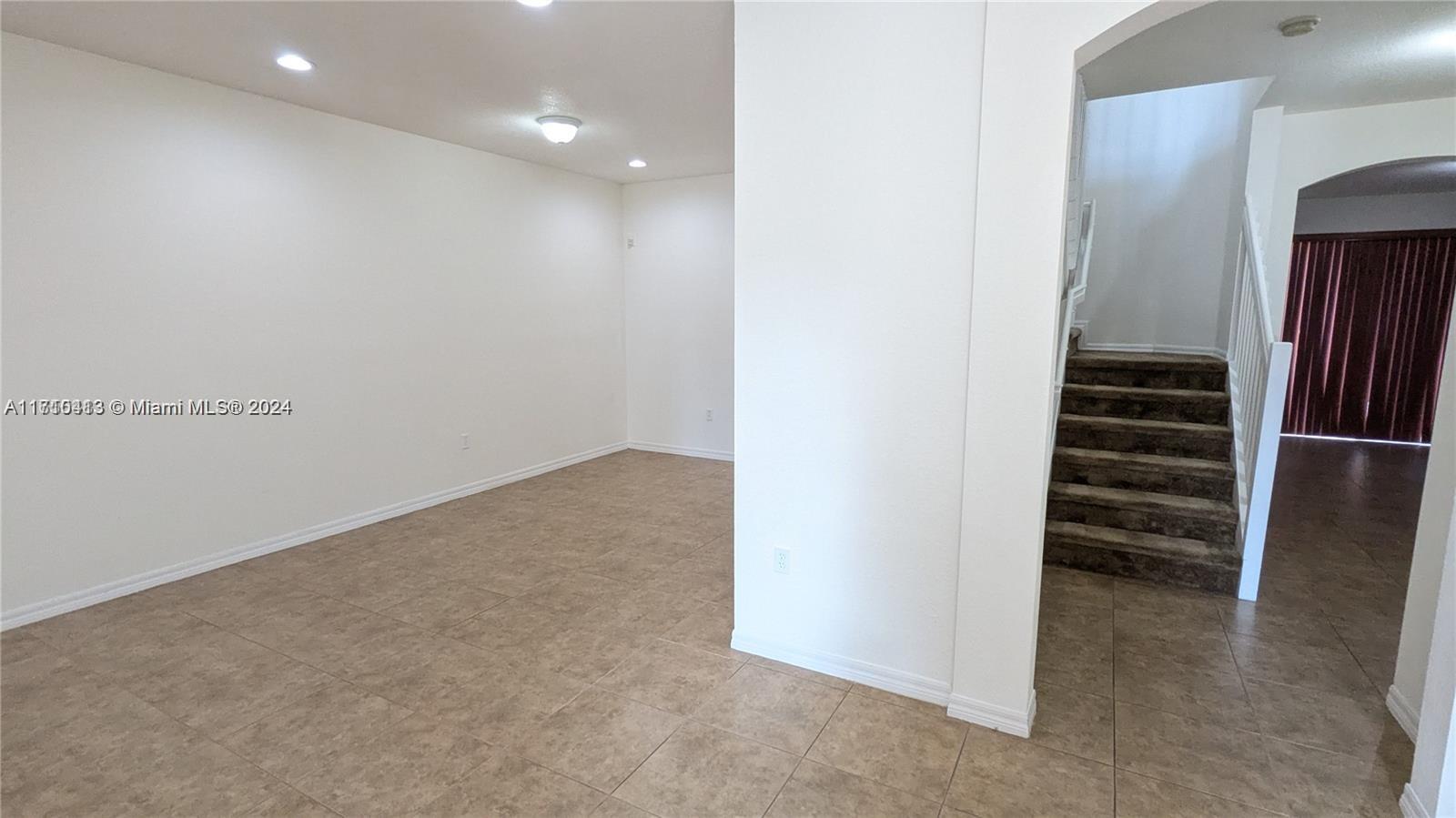 11840 Southwest 154th Avenue, Unit 11840 Miami, FL 33196 - Photo 3 of 61 an empty room with wooden floor and stairs