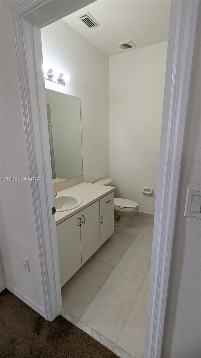 11840 Southwest 154th Avenue, Unit 11840 Miami, FL 33196 - Photo 33 of 61 a view of a bathroom with a sink a toilet and a mirror