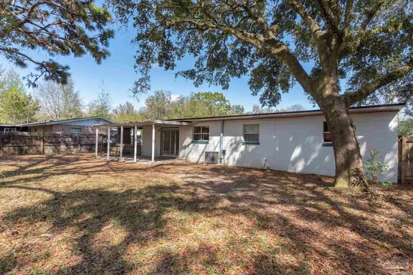 a view of a house with backyard and tree