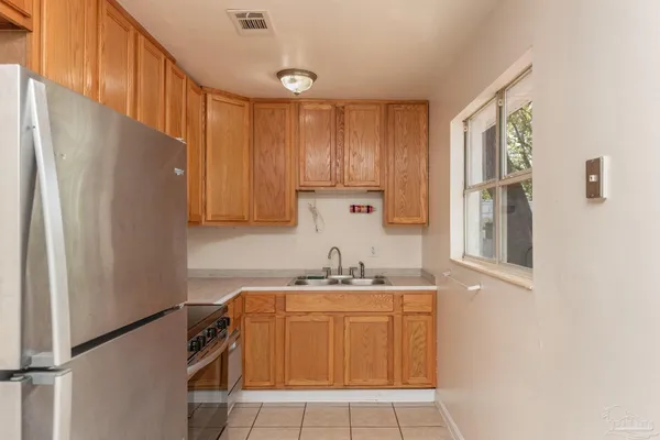 a kitchen with a refrigerator sink and cabinets
