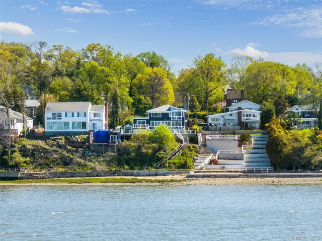 a front view of a house with swimming pool and trees