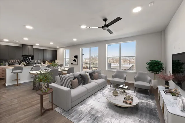 a living room with furniture kitchen view and a large window