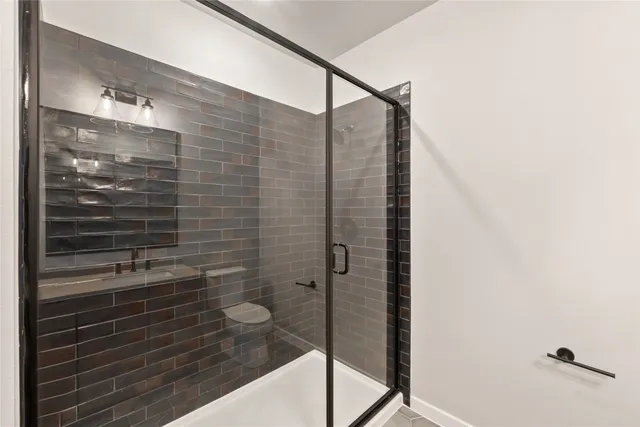 a bathroom with double vanity sink a mirror and a shower