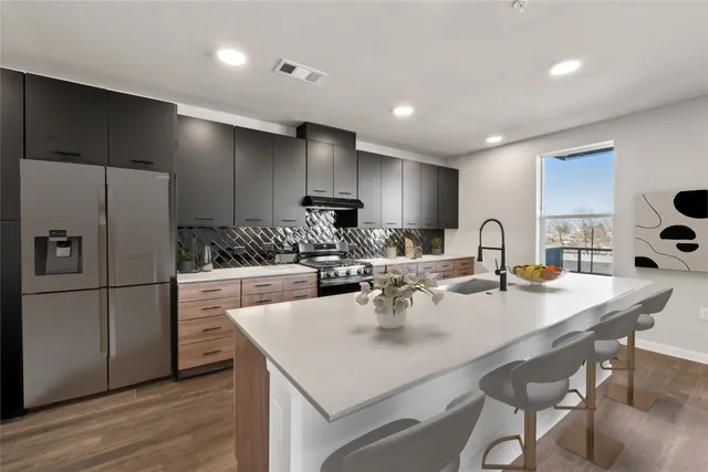 a large kitchen with kitchen island a sink a counter space and stainless steel appliances