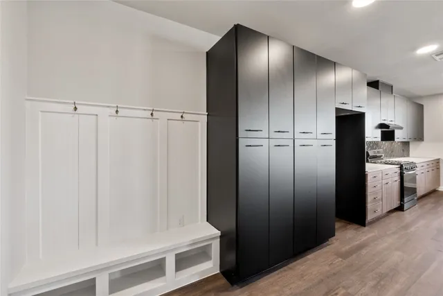 a kitchen with a refrigerator a sink a stove a dining table and chairs