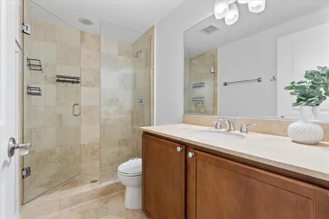 a bathroom with a granite countertop sink a toilet and shower
