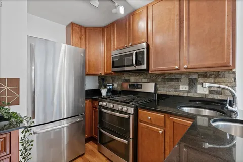 a kitchen with granite countertop a refrigerator stove and microwave