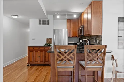a view of a kitchen with an entryway and wooden floor