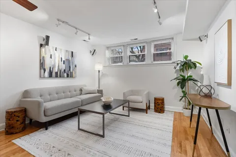 a living room with furniture and a painting on the wall