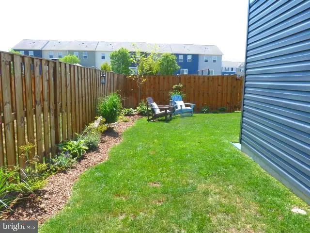 a view of a chair and table in the back yard