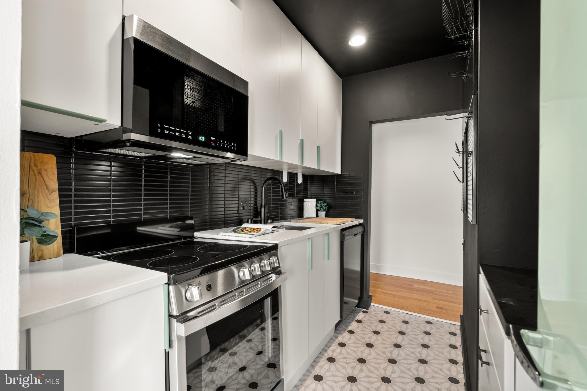 2305 18th Street Northwest, Unit 406 Washington, DC 20009 - Photo 7 of 28 a kitchen with a sink a stove and refrigerator