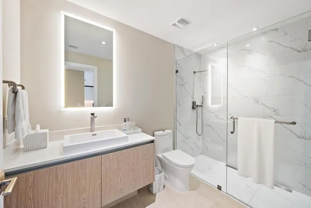 a bathroom with a sink a toilet and shower