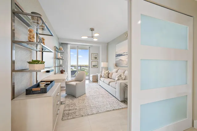 a living room with furniture a flat screen tv and a floor to ceiling window