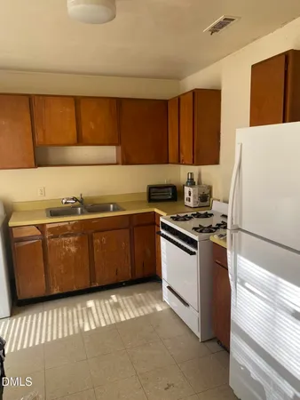 a kitchen with a sink a stove and a refrigerator