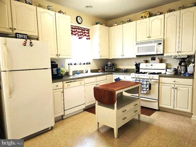 a view of kitchen with refrigerator and window