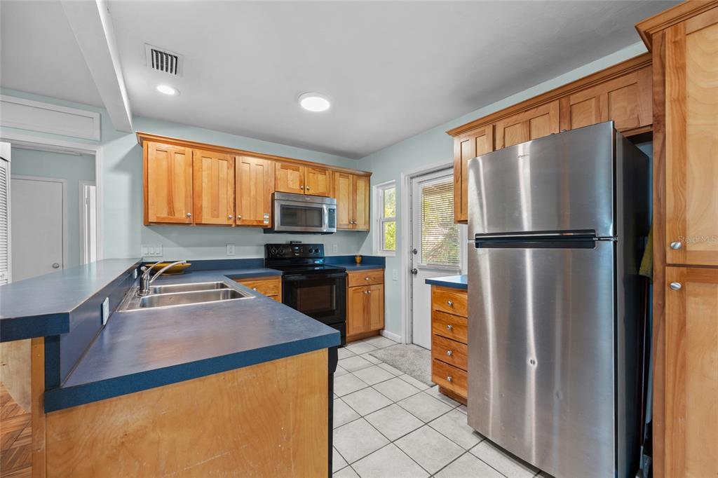 601 Northwest 36th Drive Gainesville, FL 32607 - Photo 11 of 36 a kitchen with stainless steel appliances granite countertop a refrigerator a stove top oven and a sink