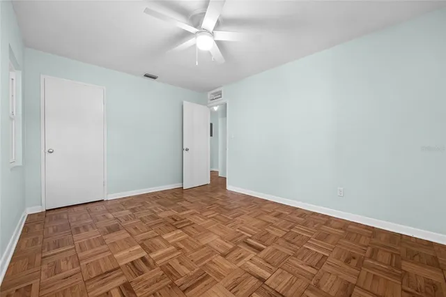 a view of empty room with wooden floor