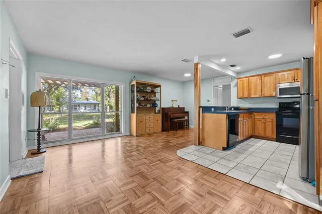 a large kitchen with granite countertop a large counter top stainless steel appliances and cabinets