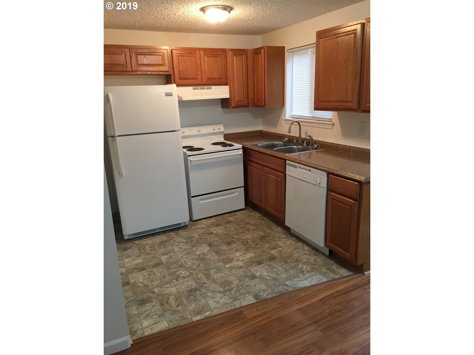 9733 Southeast Foster Road Portland, OR 97266 - Photo 5 of 16 a kitchen with a refrigerator and a stove