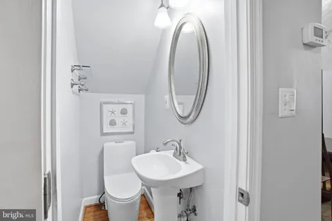 a bathroom with a toilet a sink and a mirror