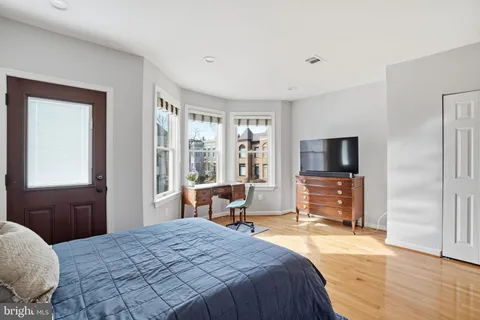a bedroom with a bed and wooden floor