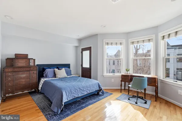 a bedroom with a bed and large windows