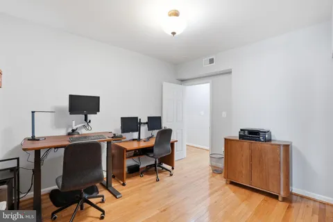 a view of a workspace with furniture and wooden floor