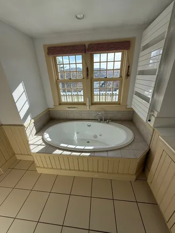 a bath tub sitting in a bathroom next to a window