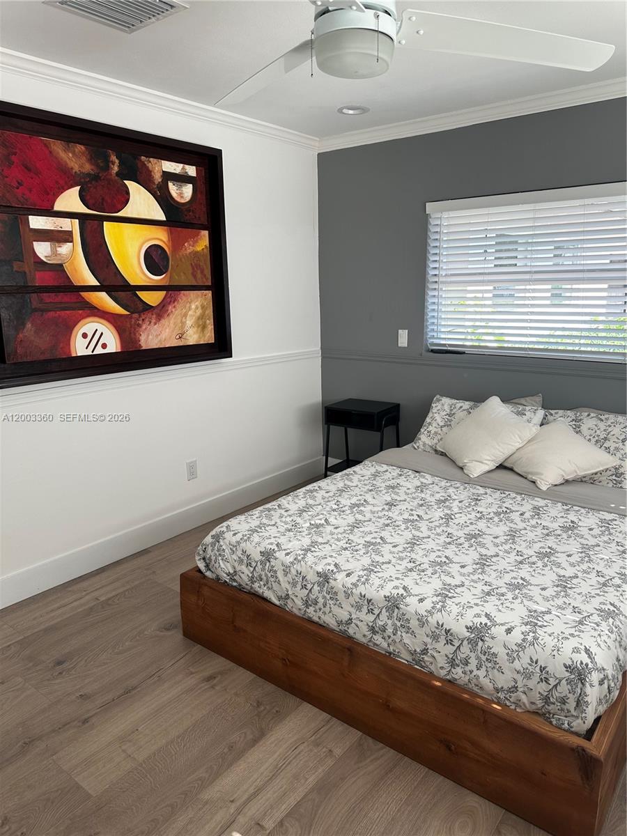 1251 Southwest 11th Terrace Boca Raton, FL 33486 - Photo 26 of 47 a bedroom with a bed and painting on the wall