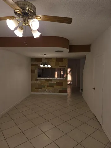 a view of livingroom and a chandelier fan